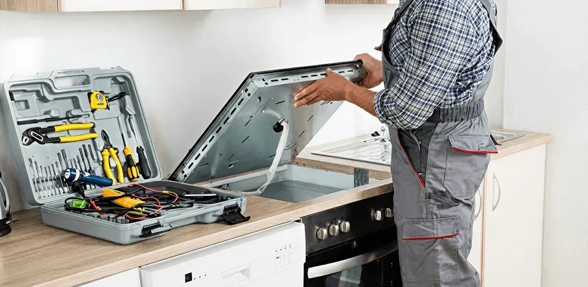 Handyman repairing a cooktop and checking wiring connections in Ann Arbor, MI
