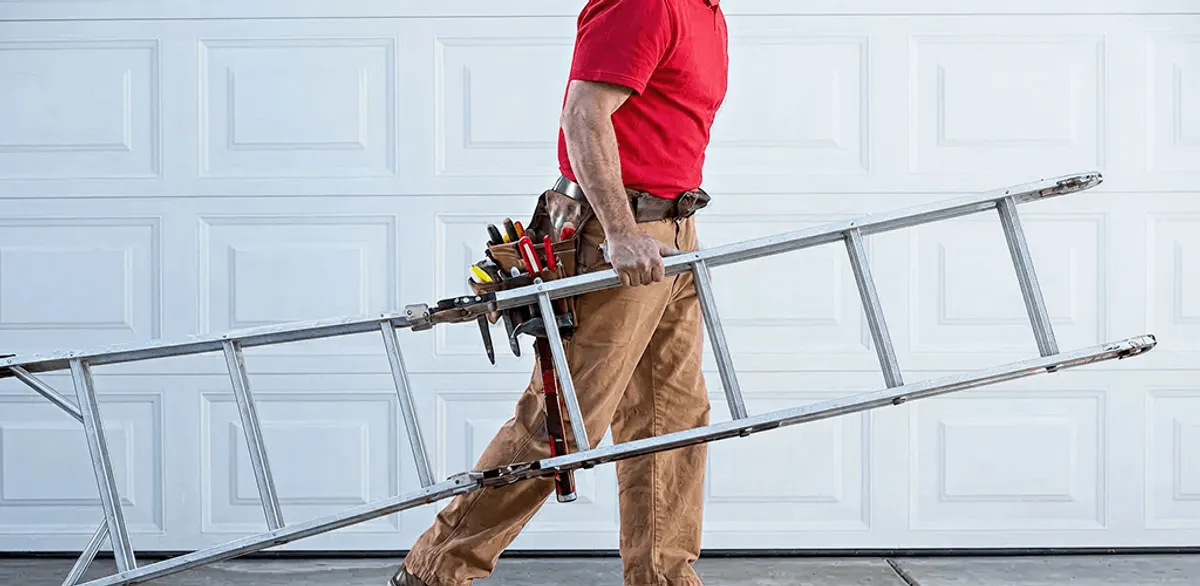 Garage door repair technician arriving with tools and ladder in Ann Arbor, MI